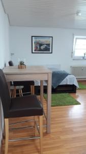 uma mesa e cadeiras num quarto com uma cama em Business Apartment in Weil am Rhein em Weil am Rhein