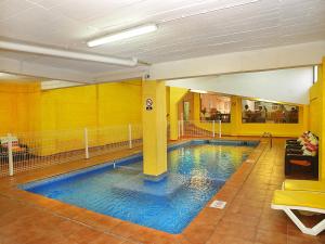 a large swimming pool in a building with blue water at Portimão Center Hotel in Portimão