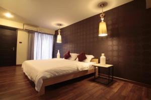 um quarto com uma cama grande e duas luzes pendentes em Diary Suite em Nakhon Pathom