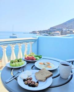 una mesa con platos de comida en la parte superior de un balcón en Tassos Apartments II, en Agia Marina