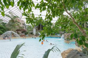 a large swimming pool with people in it at Hotel Kempense Meren by Sunparks in Mol