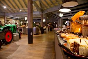a bakery with a long counter with some food on it at Hotel De Vossemeren by Center Parcs in Lommel