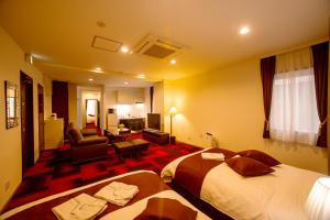 um quarto de hotel com duas camas e uma sala de estar em Condominium Stella Site em Hakodate