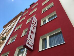 un bâtiment rouge avec un panneau sur son côté dans l'établissement Hotel Royal, à Francfort-sur-le-Main