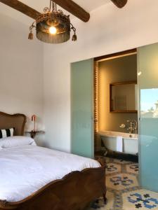 - une chambre avec un lit, une baignoire et un miroir dans l'établissement Casa rural El Ralenco, à Lécera