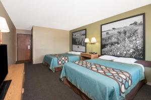 a hotel room with two beds and a tv at Super 8 by Wyndham Milbank SD in Milbank