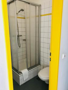 a bathroom with a toilet and a glass shower at Jugendherberge Hannover in Hannover