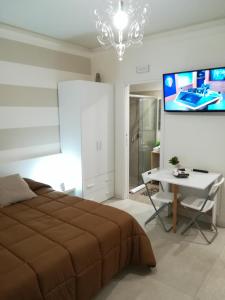 a bedroom with a bed and a desk and a tv at Guest House B&B Via Marina in Reggio di Calabria