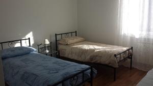 a bedroom with two beds and a window at Casa La Rosa in Montegrotto Terme