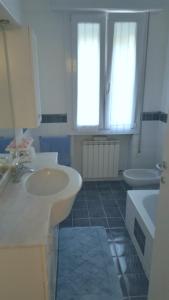 a bathroom with two sinks and a tub and two windows at Casa La Rosa in Montegrotto Terme +13 photos