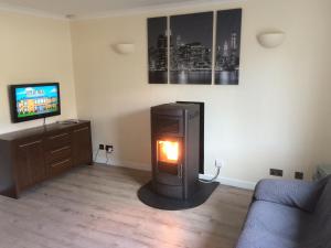 a living room with a fire place in the middle of the room at 16 East Street Sandwick Stornoway in Sandwick