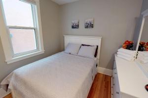 a white bedroom with a bed and a window at Bright, Clean, Private. In the Heart of Downtown! Parking, Wi-Fi and Netflix included in Ottawa