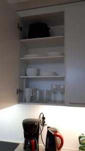 una credenza con ciotole e bicchieri e un bollitore per il tè di Arctic Studio a Rovaniemi