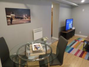a dining room with a glass table and chairs at Fantastic and Modern Downtown 1-Bed Basement Apt., parking Wi-Fi and Netflix included in Ottawa