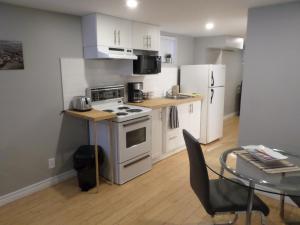 a kitchen with a white stove and a table at Fantastic and Modern Downtown 1-Bed Basement Apt., parking Wi-Fi and Netflix included in Ottawa