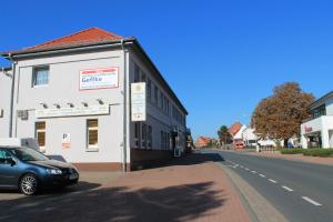 een auto geparkeerd naast een gebouw in een straat bij Gaststätte Alt Garbsen in Garbsen