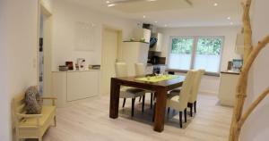 a kitchen and dining room with a wooden table and chairs at Im Corveyer Wäldchen in Traben-Trarbach
