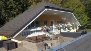 una piccola casa con portico e divano di Im Corveyer Wäldchen a Traben-Trarbach