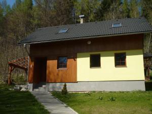 una casa di colore marrone e giallo di Chata Koutík a Loučná nad Desnou