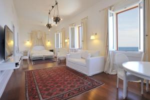 a living room with a white couch and a rug at Villa Las Tronas Hotel & SPA in Alghero +33 photos