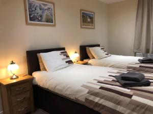 2 camas en una habitación con 2 lámparas en las mesas en White Horse Tavern, en Telford