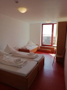2 Betten in einem Zimmer mit Fenster in der Unterkunft Naturfreundehaus Bodensee in Radolfzell am Bodensee
