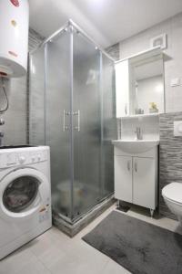 a bathroom with a shower and a washing machine at Seher in Sarajevo