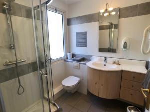 a bathroom with a toilet and a sink and a shower at Hôtel Méditerranée in Le Lavandou