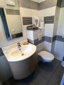 a bathroom with a sink and a toilet at Hôtel Méditerranée in Le Lavandou