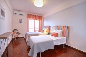 um quarto de hotel com duas camas e uma janela em In Faro with Sea View em Faro
