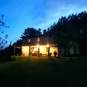 una casa iluminada por la noche con luces en Casa Carballeira, en Villarfernando