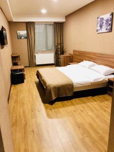 a bedroom with a large bed and a wooden floor at Lords Hotel in Tbilisi City