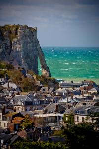 a town with houses and a mountain in the background at Domaine Saint Clair - Le Donjon in Étretat