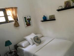 a bedroom with two white beds and a window at Chao Mamá Hostal in Santo Domingo