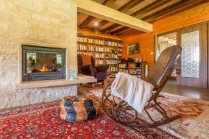 a living room with a rocking chair in front of a fireplace at Boutique Hotel Japodi B&B in Mrkopalj