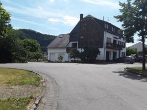 a large white house on a street with a driveway at Ferienhaus Nicole in Piesport