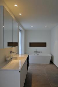biała łazienka z wanną i umywalką w obiekcie Maison la Belle Vue w mieście Mont-de-l'Enclus