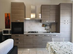 uma cozinha com armários de madeira, um lavatório e uma mesa em Casa Vacanza Pse em Porto SantʼElpidio