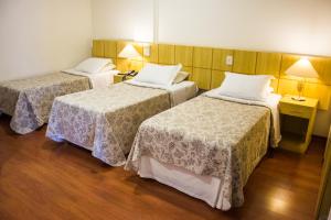 Un pat sau paturi într-o cameră la Serra Negra Palace Hotel