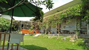 a garden with a table and an umbrella at Condro Wulan Hostel in Malang