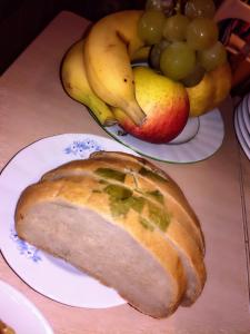 a loaf of bread on a plate with fruit on a table at Pension Behnisch in Strehla