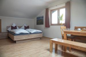 a bedroom with a bed and a table and a dining room at Ferienhaus am Riedl in Siegsdorf