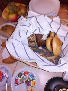 a table topped with a basket of bread and fruit at Pension Behnisch in Strehla