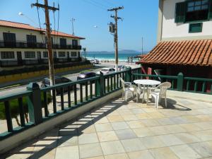 um pátio com uma mesa e cadeiras junto à praia em Cond. Hotel Âncora em frente Praia do Peró em Cabo Frio