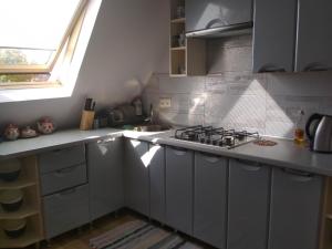 a white kitchen with a stove and a sink at Грушевського 13 in Berehove