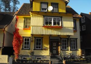 ein gelbes Haus mit Blumen davor in der Unterkunft Brummers Ferienwohnung in Wildemann