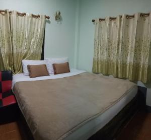 ein großes Bett mit zwei Kissen in einem Schlafzimmer in der Unterkunft Phu Chaem House in Mae Chaem