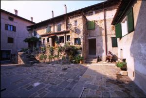 a person sitting on a bench in front of a building at Residence Viale del Sole in Grado