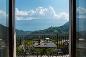uma mesa e cadeiras numa varanda com vista em Casa Miramonti em Tremosine Sul Garda