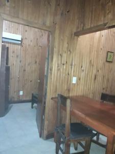 a room with a wooden wall and a wooden table at Cabañas Los Timbó in Ituzaingó